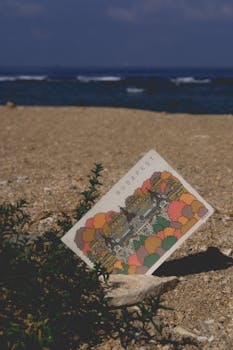 Artistic postcard of Budapest rests on a sandy beach with ocean in the background.