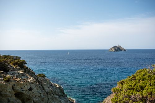 Free Peaceful coastal view with distant island, blue sea, and clear sky. Stock Photo