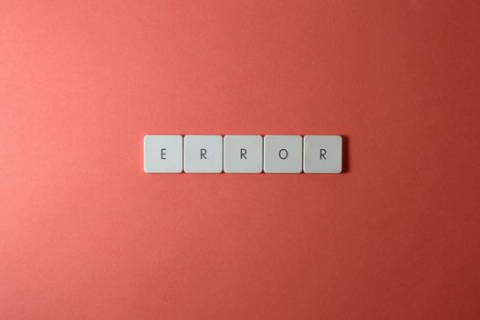 White letter tiles spelling 'ERROR' on a red backdrop, offering a minimalist design concept.