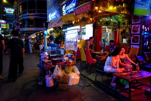 Explore the vibrant street food culture of Saigon at night, bustling with life and flavors.