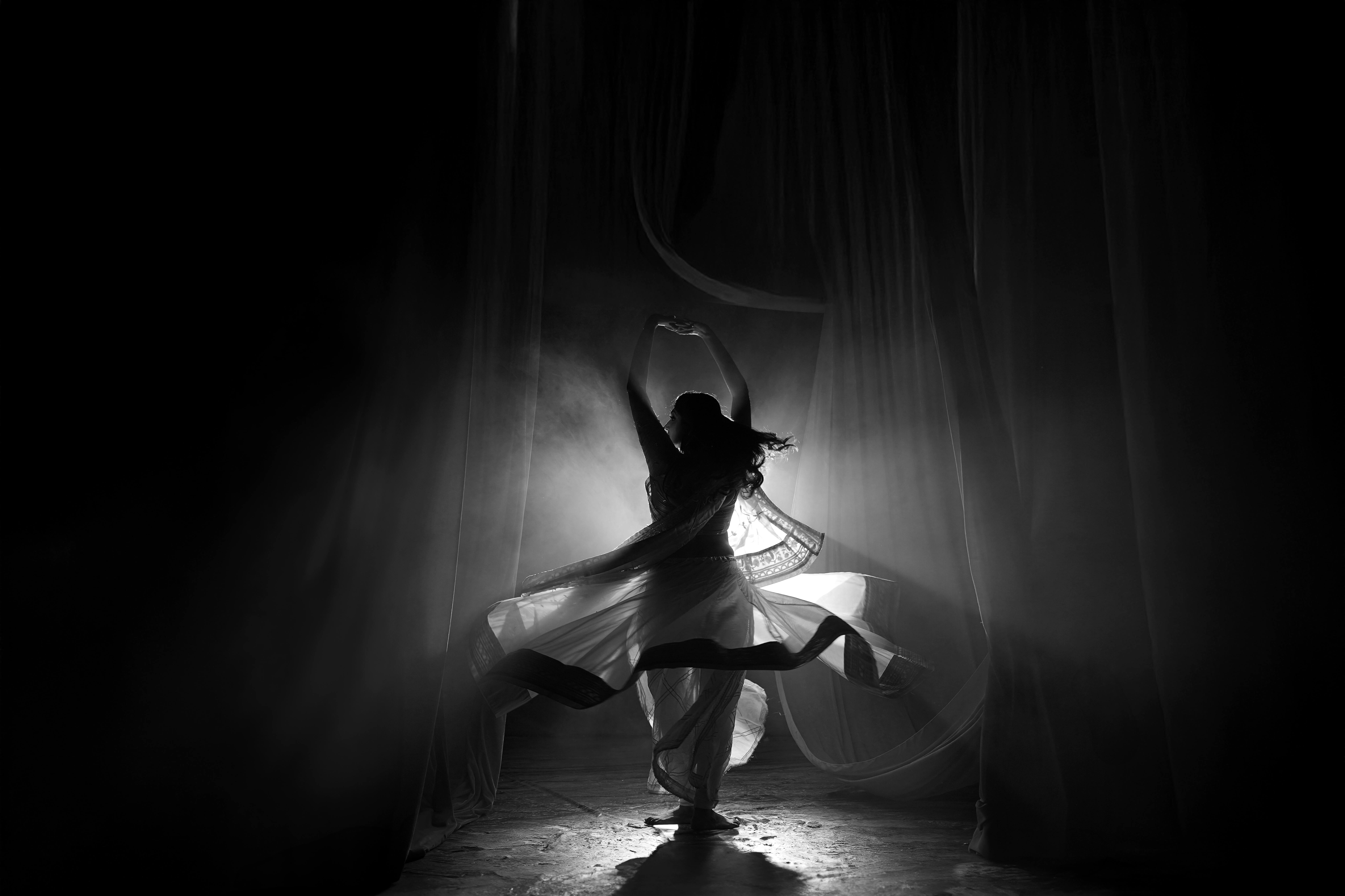 Captivating silhouette of a traditional Indian dancer performing under soft lighting indoors.