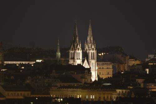 Free Night view of an illuminated church with gothic architecture in a cityscape. Stock Photo