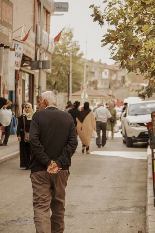Free A bustling urban street scene with diverse pedestrians and background shops. Stock Photo