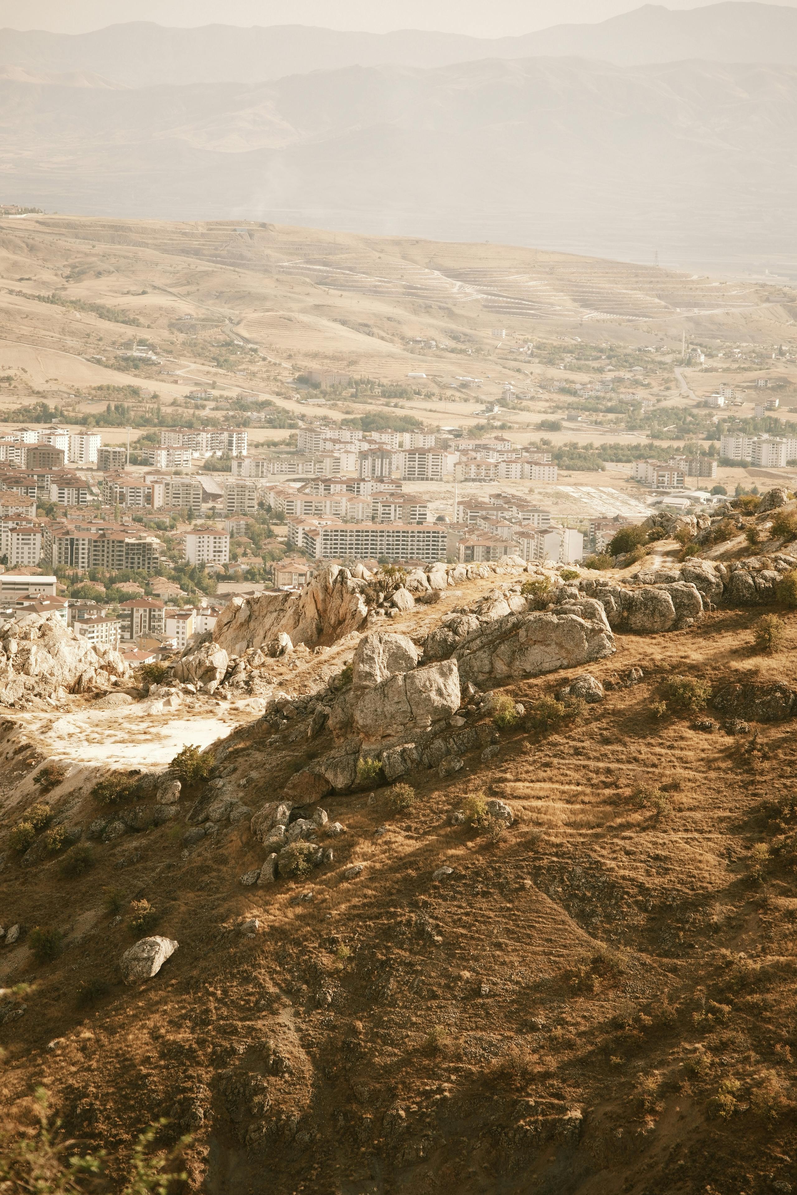 Stunning aerial view of a city surrounded by rocky hills and arid landscapes.