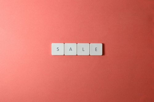 Free A minimalist flat lay of the word SALE spelled with letter tiles on a red background, perfect for promotions. Stock Photo