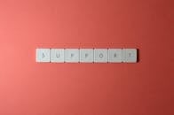 特写镜头中，红色背景上用键盘按键拼出“支持”二字