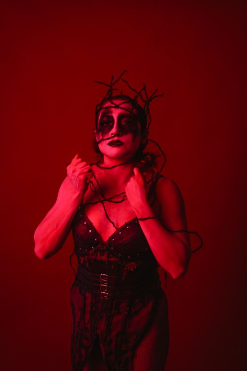 Free A striking artistic portrait with bold makeup in vibrant red lighting. Stock Photo