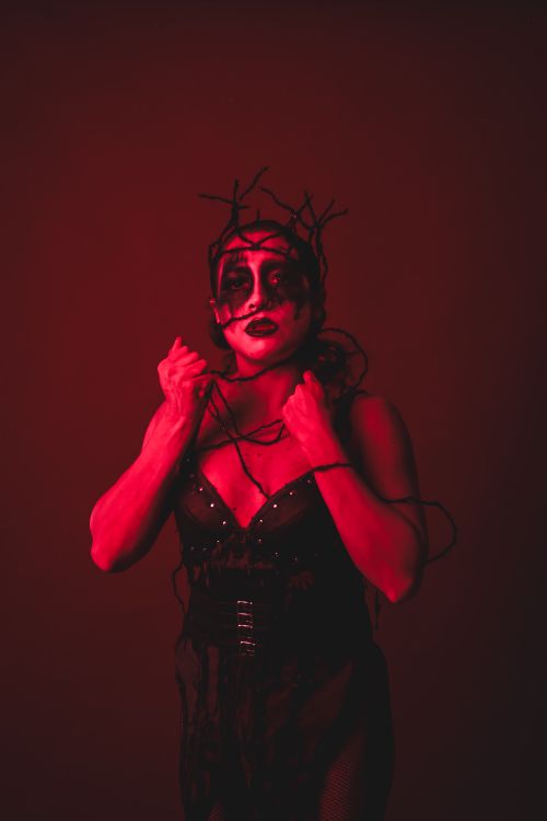 Free Dark, evocative portrait of a woman with gothic makeup and red lighting. Stock Photo