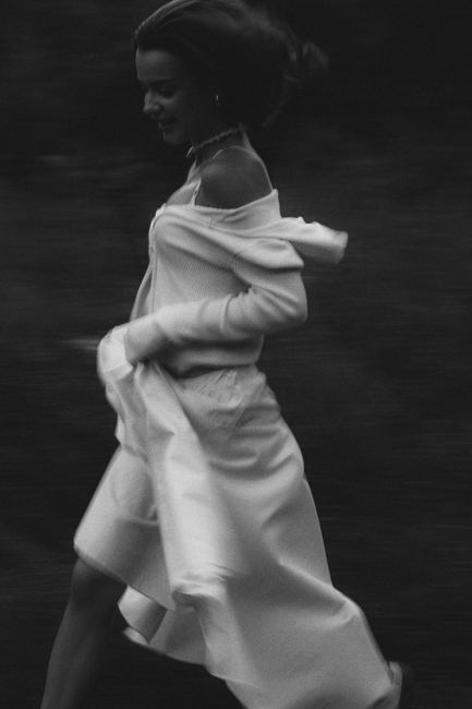 Side view of a woman in motion, wearing flowing clothing in monochrome.