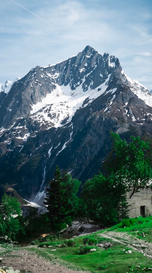 Free Majestic snowcapped mountain with lush green foreground, perfect for travel and nature themes. Stock Photo
