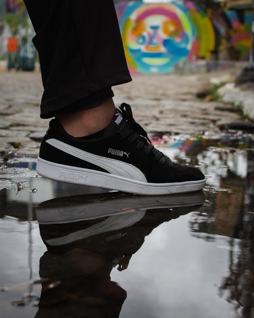 A Person in White and Black Puma Suede Shoe