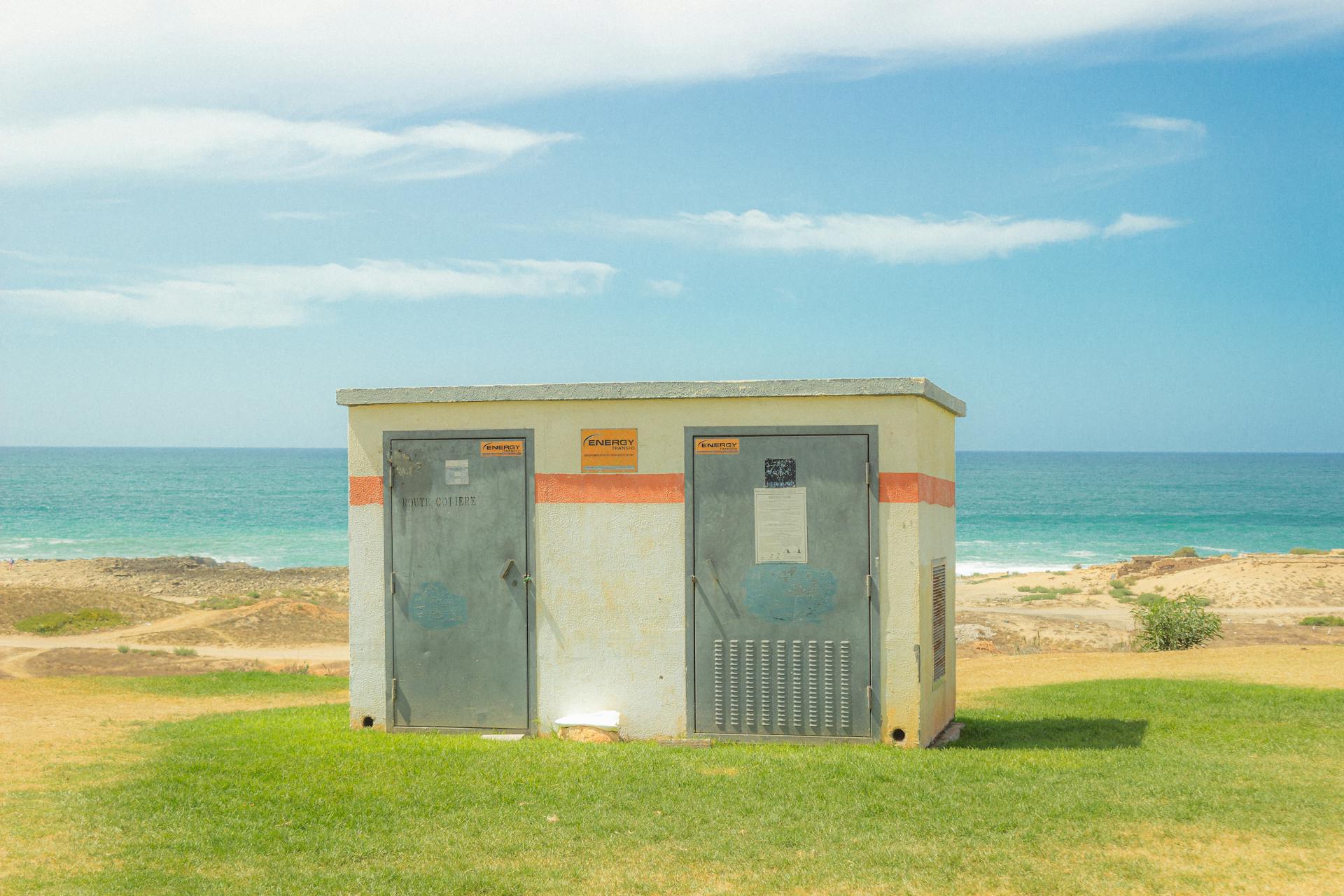Utility box by the sea under a blue sky. Perfect for industrial-themed concepts.