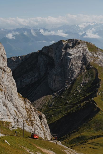 Breathtaking view of a red train navigating through the rugged Swiss Alps.