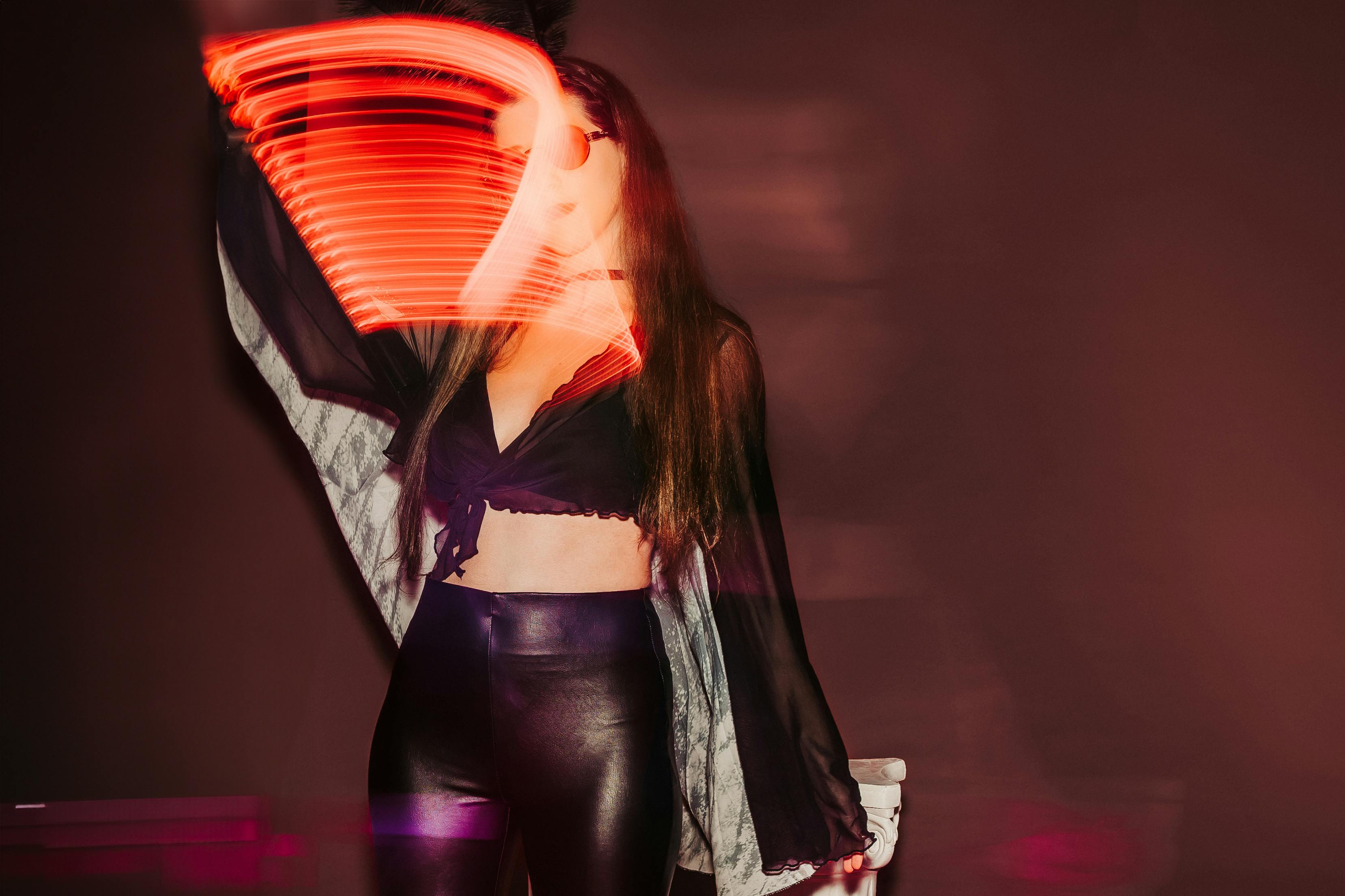 Captivating image of a woman with vibrant light painting effect, exuding mystery.
