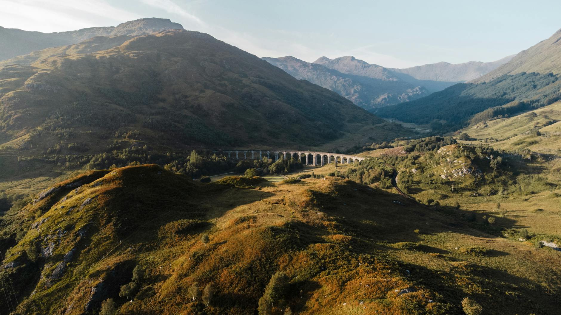 West Highland Line Train Journey Through Scottish Highlands With Glenfinnan Viaduct, Lochs, Heather, And Ben Nevis In The Background