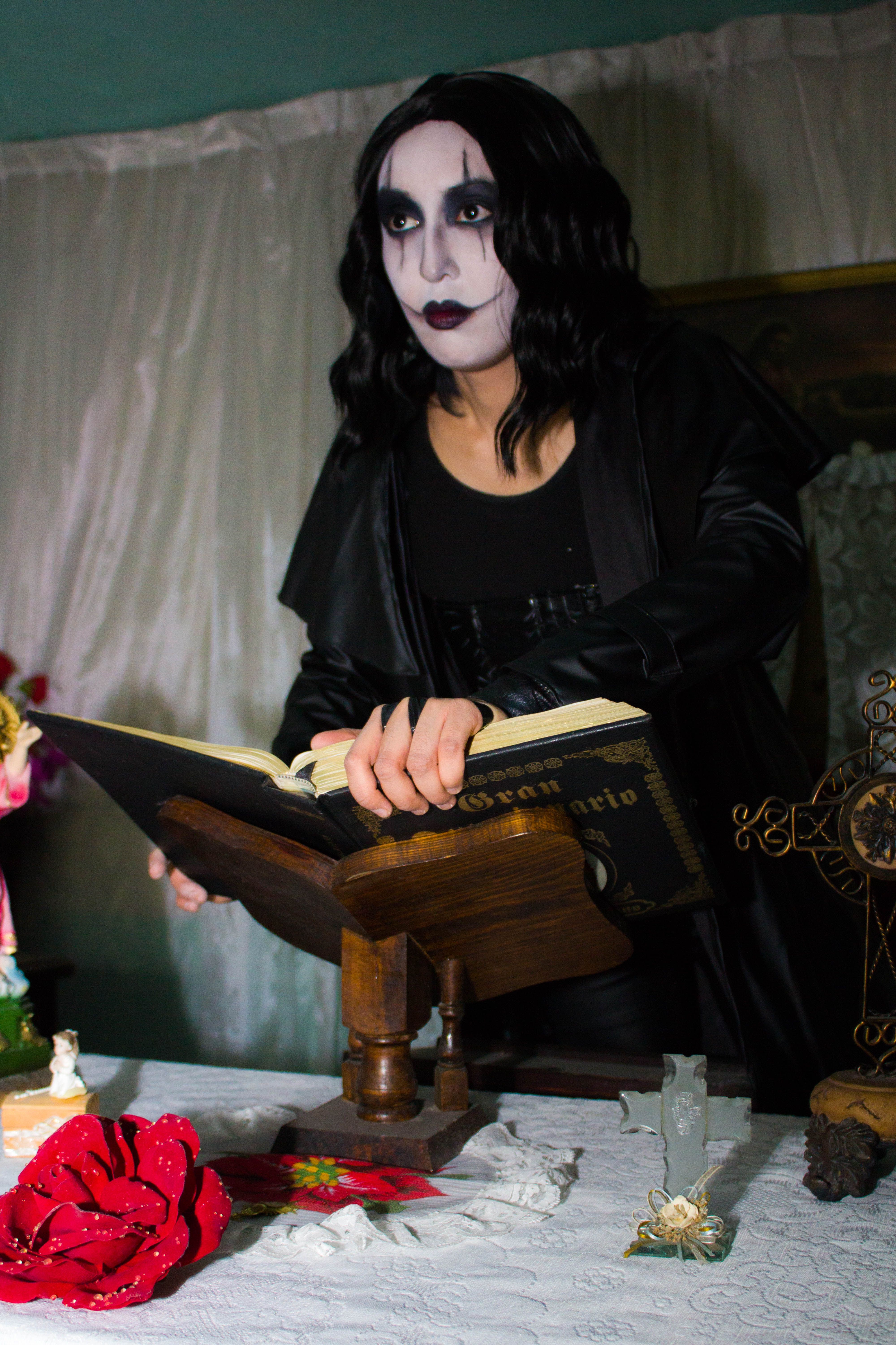 Gothic themed person in dramatic makeup reading a book · Free Stock Photo