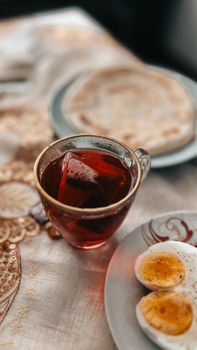 Inviting breakfast scene with a warm cup of tea and boiled eggs on a table.
