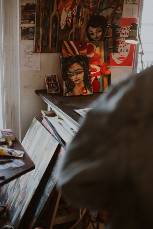Free Cozy Parisian studio filled with vibrant, abstract portraits on canvases. Stock Photo