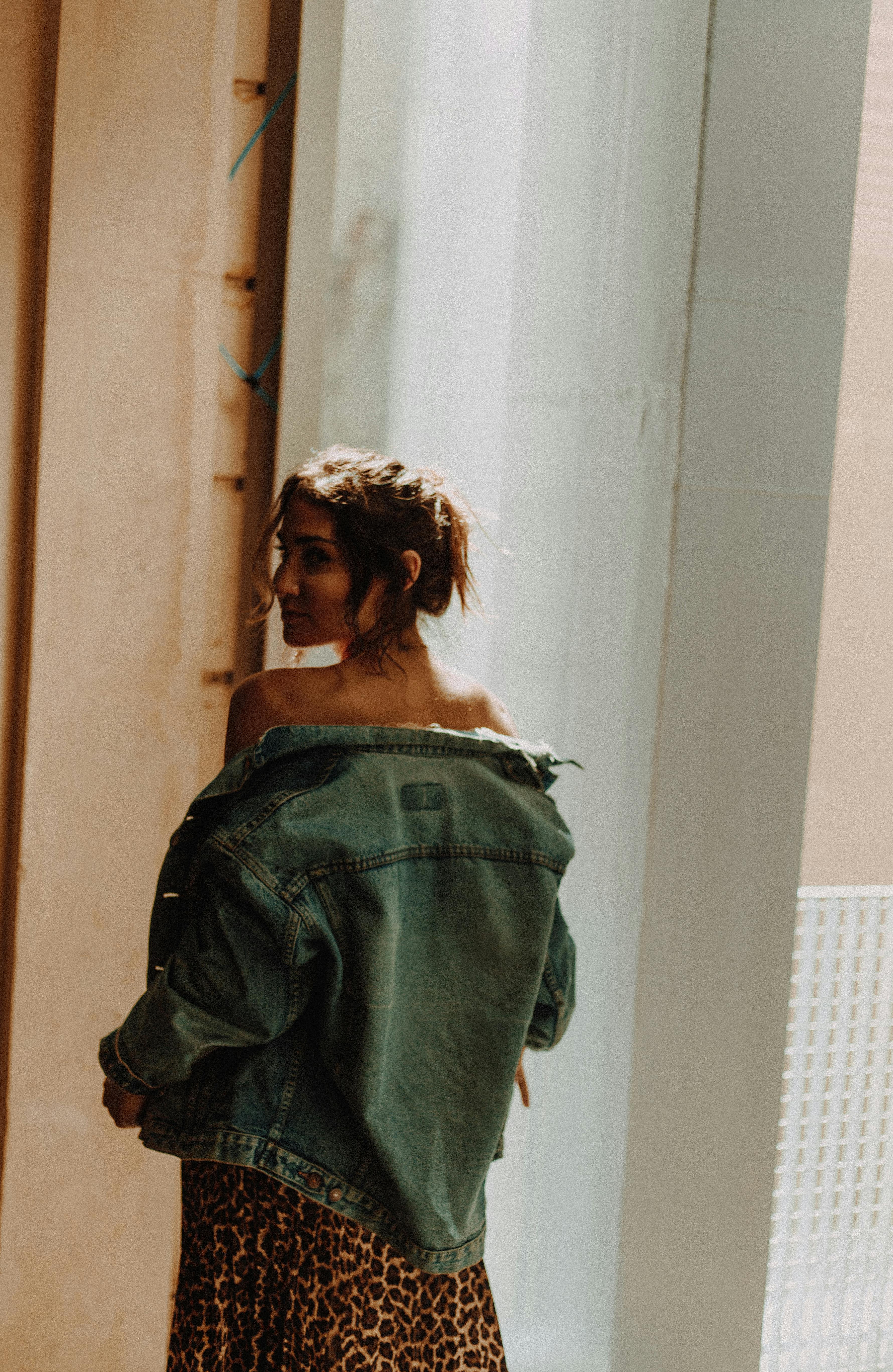 一位时尚女性在巴黎都市环境中穿着牛仔夹克摆出姿势