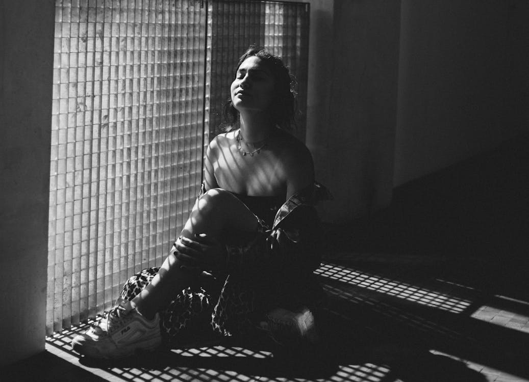 Free Photo Of Woman Sitting Beside The Wall Stock Photo