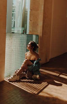 室内，一位穿着牛仔夹克的时尚女士沐浴在温暖的阳光下