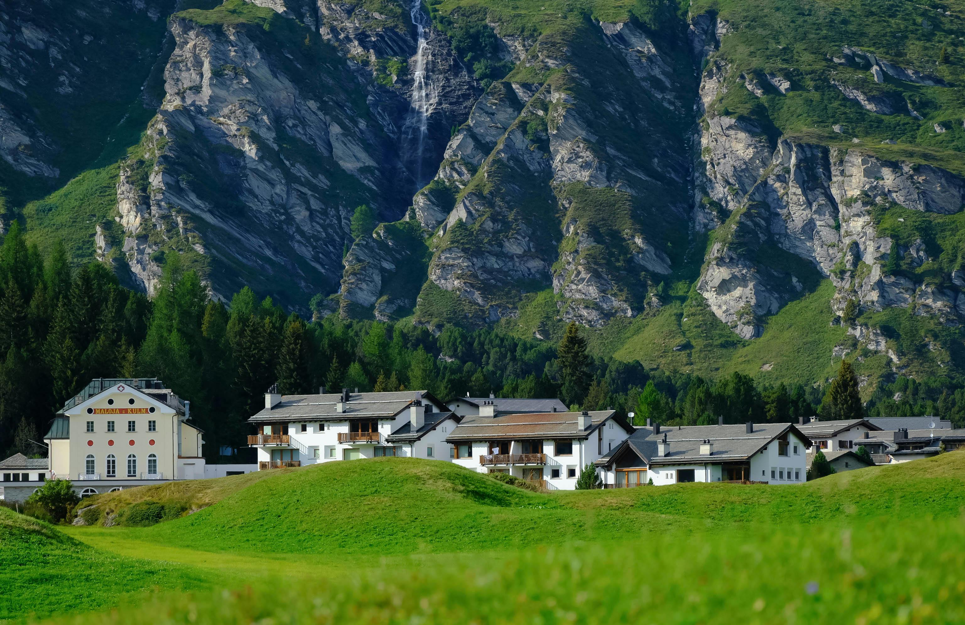 Charming alpine village nestled against a dramatic mountain landscape.