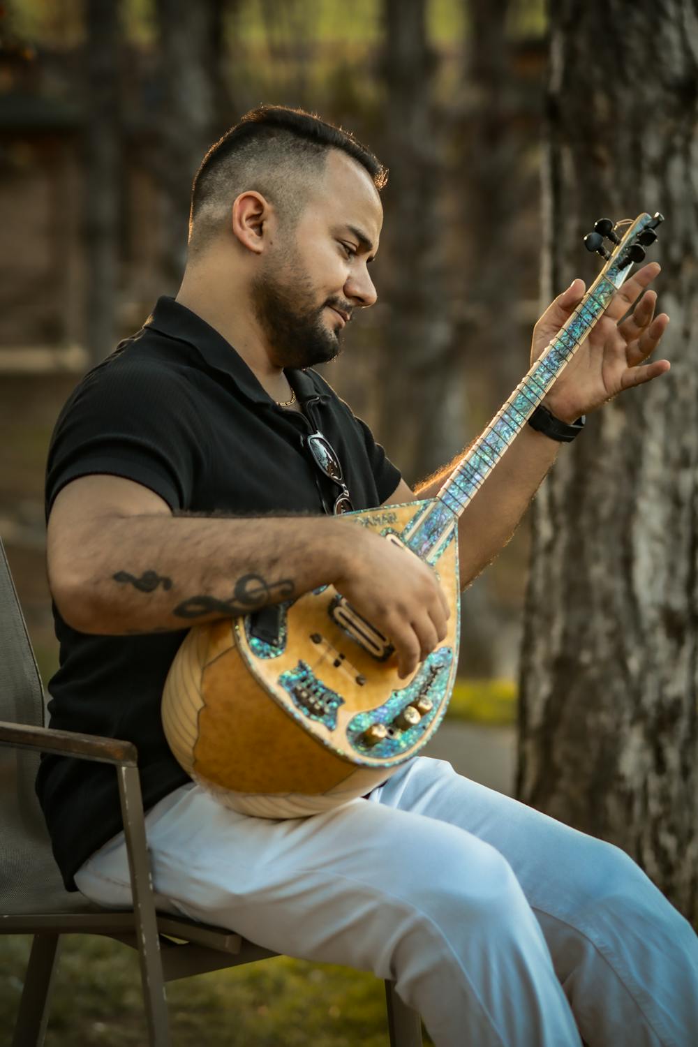 Man Playing Stringed Instrument Outdoors · Free Stock Photo