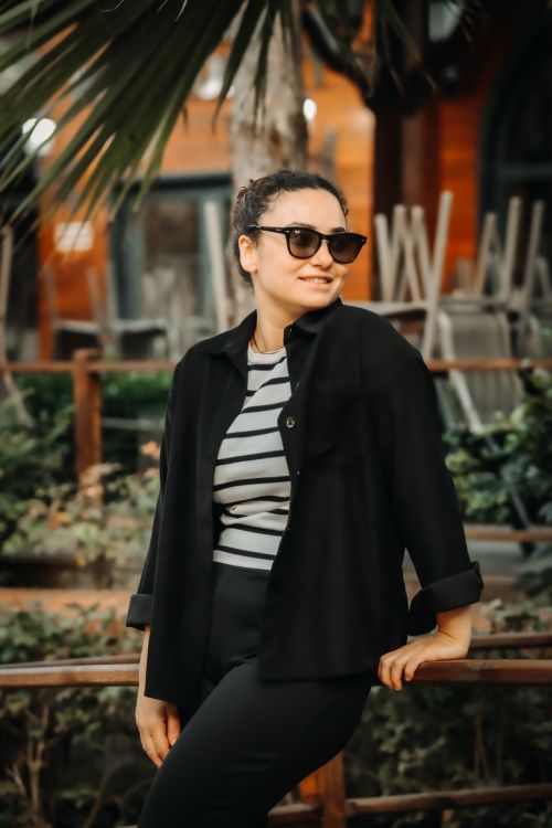 Free Confident woman in sunglasses posing outdoors in casual chic attire. Stock Photo