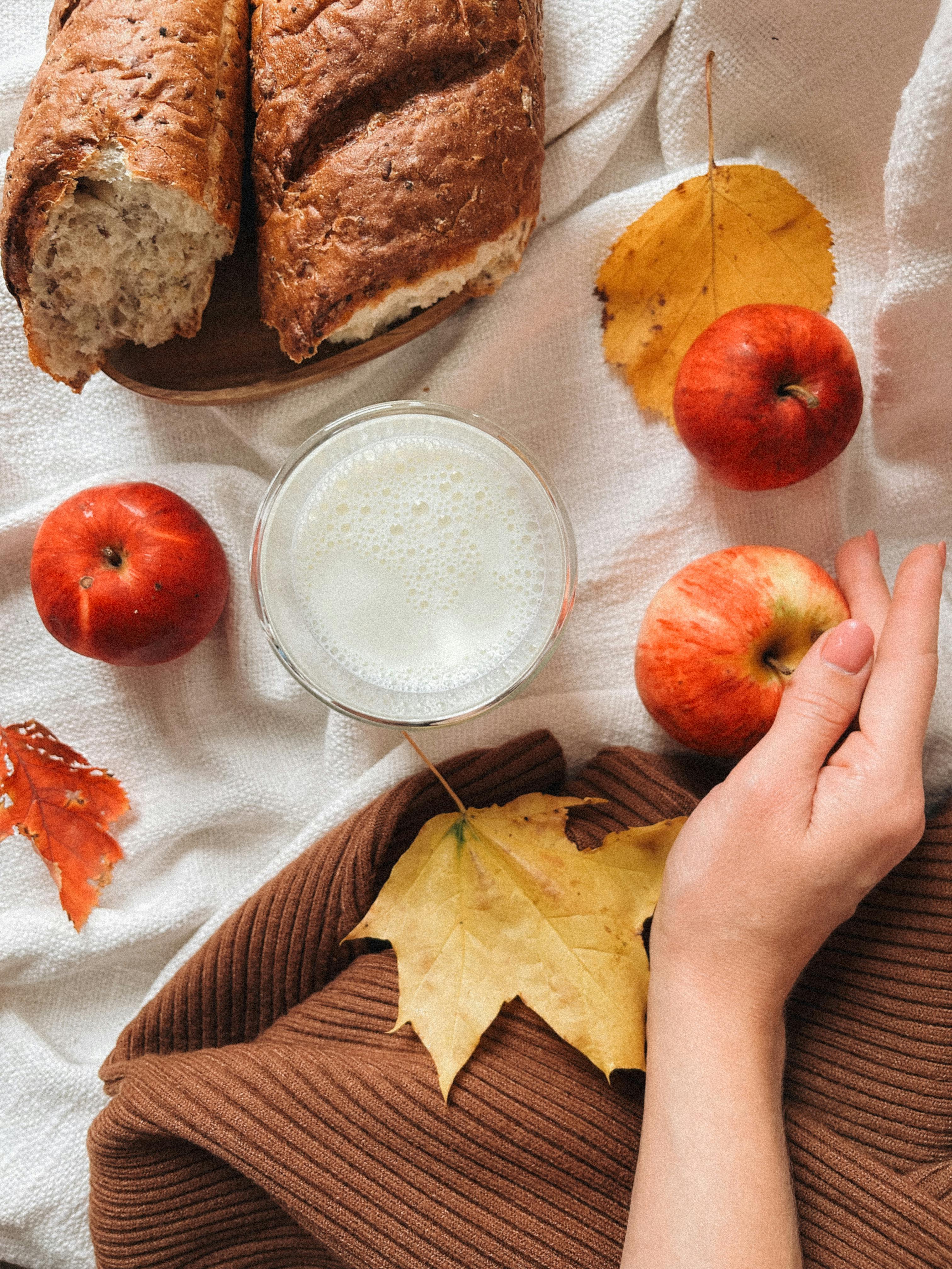 Warm autumn still life featuring bread, apples, and milk