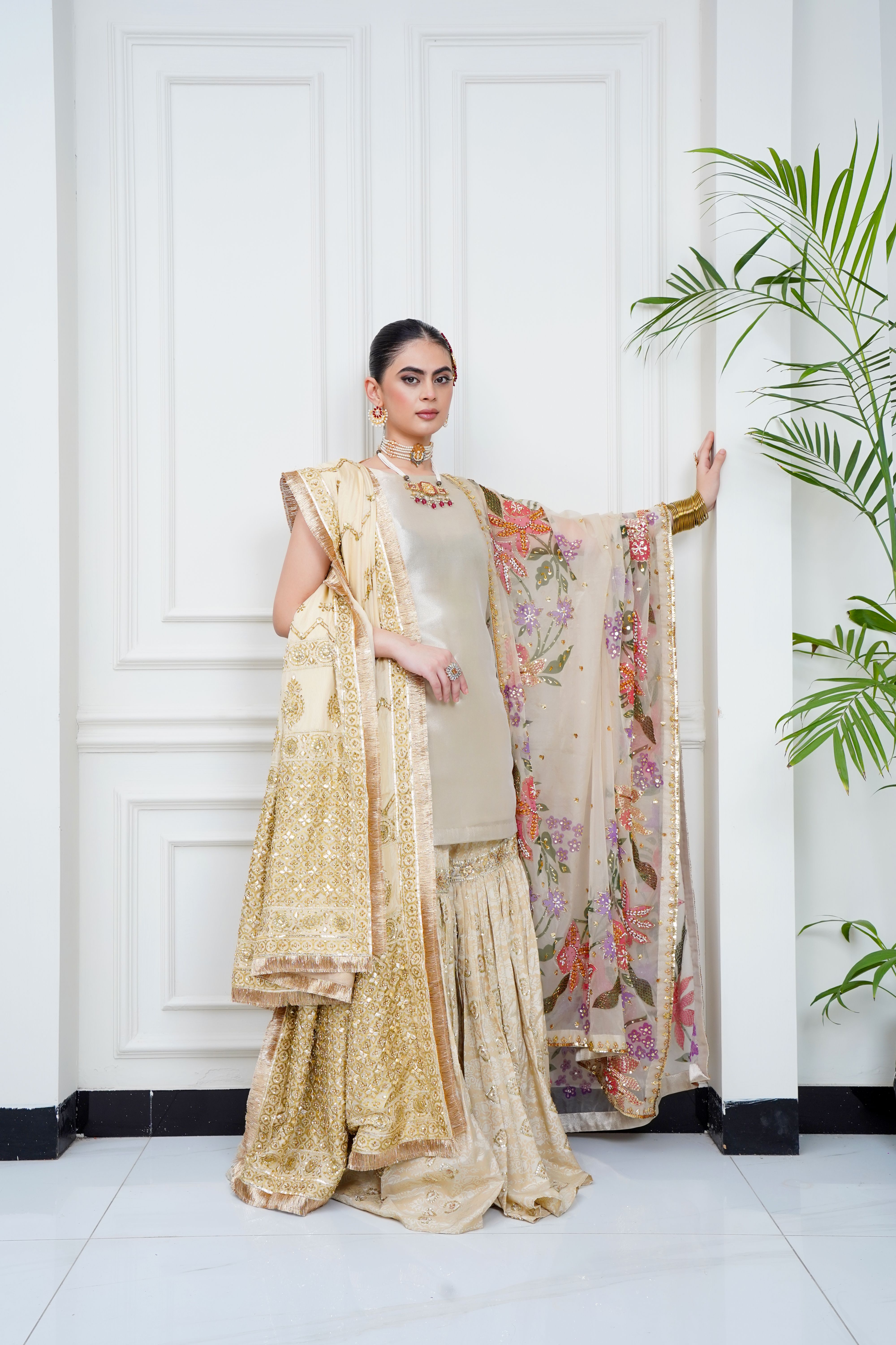 A stunning portrait of a woman in luxurious eastern bridal attire, indoors.