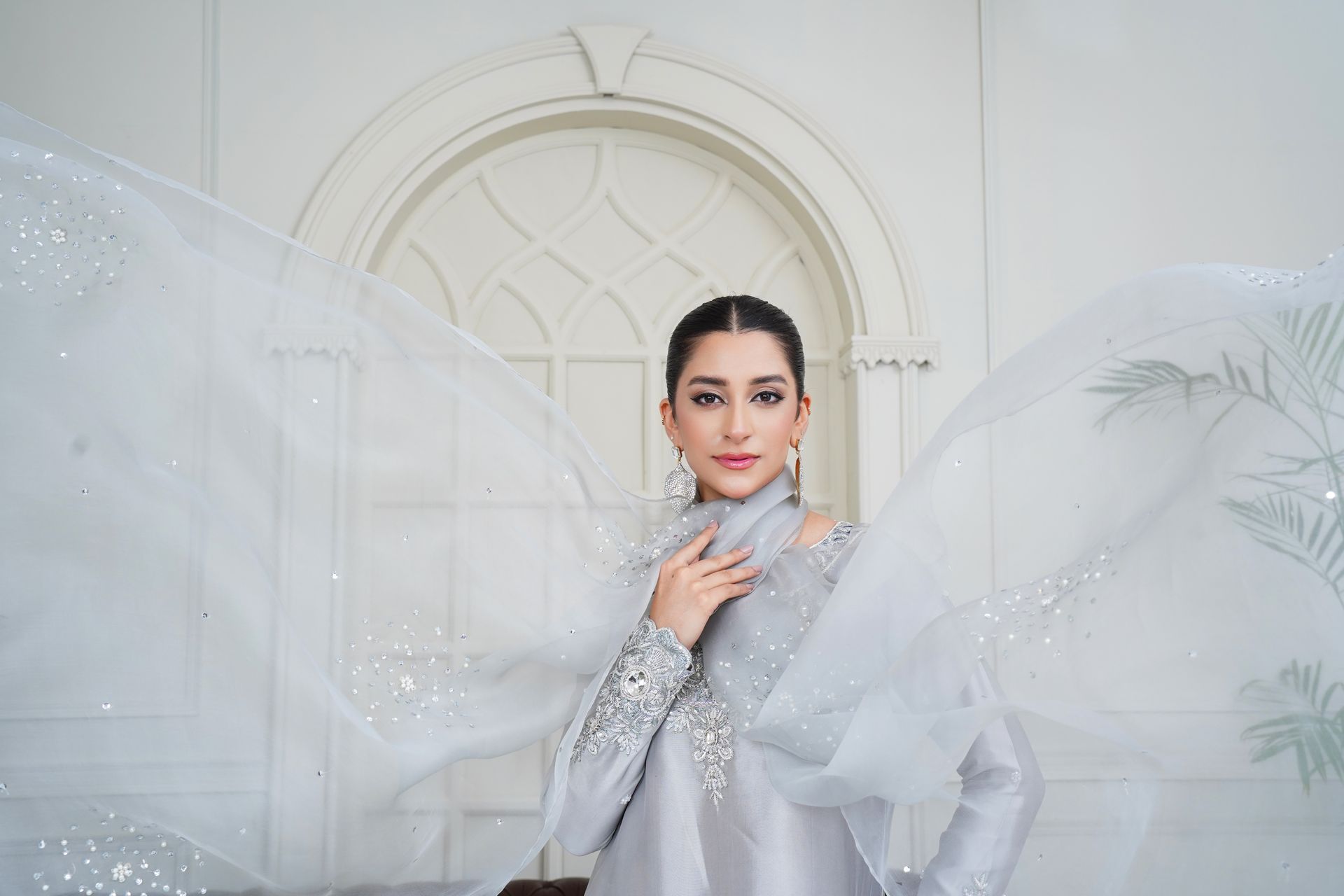 Stunning portrait of a woman wearing elegant Eastern bridal fashion with intricate embroidery.