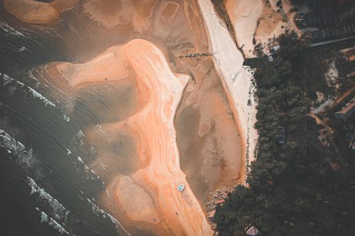 Free Stunning aerial view of a beach with sandy textures and coastal landscape. Stock Photo