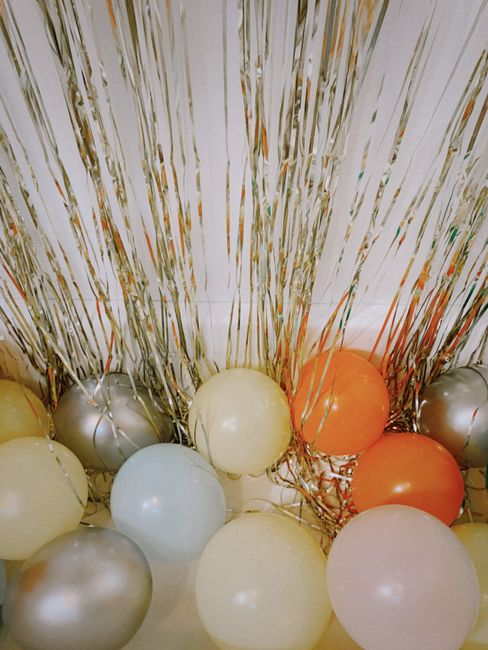 Vibrant balloons and metallic tinsel backdrop for a lively celebration.