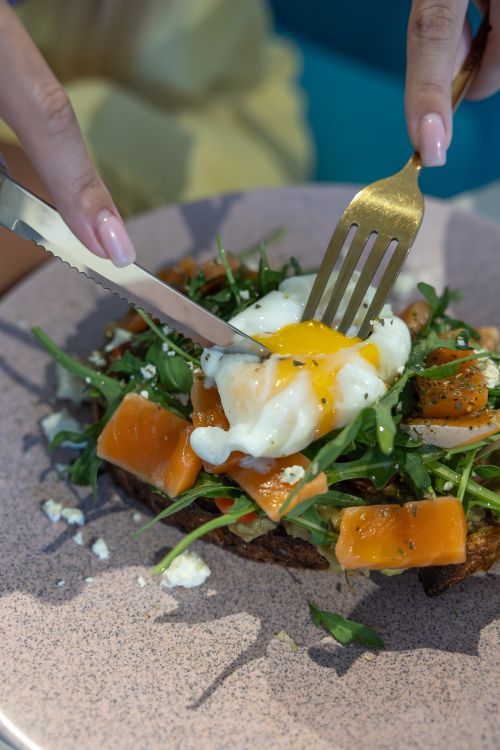 Free Appetizing smoked salmon and poached egg on a bed of greens; ideal breakfast choice. Stock Photo