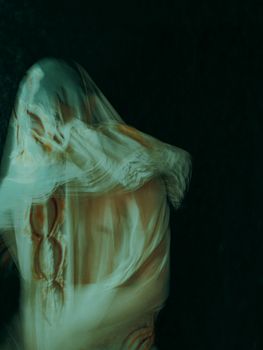 Ethereal and mysterious motion blur of a draped figure, creating an abstract art effect.