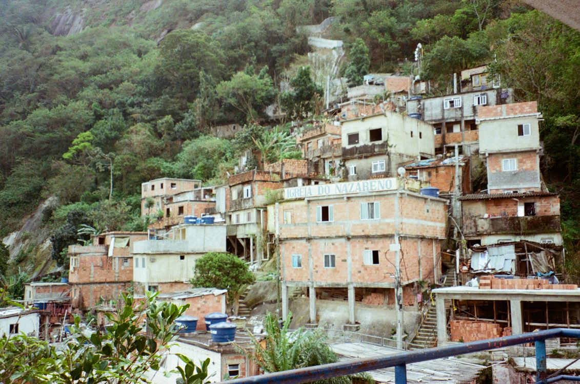 Favela colorida em encosta de morro no Brasil, representando desafios urbanos e desigualdade social