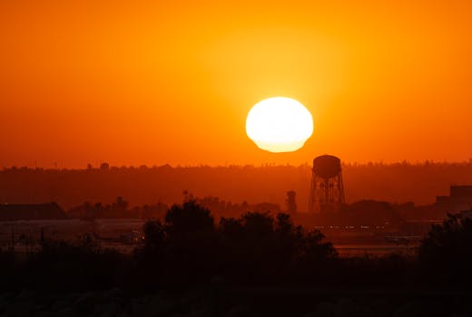 A stunning sunset featuring a prominent water tower in San Bernardino, capturing the rich oranges of the horizon.