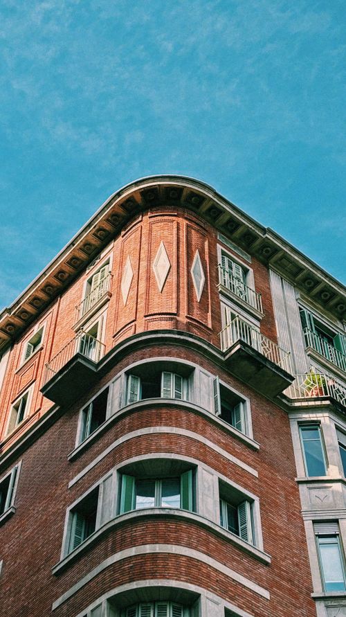 Free Capture of a distinctive architectural facade in Barcelona, Spain showcasing classic details against a clear blue sky. Stock Photo