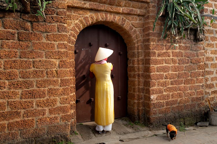 Woman Standing Beside Wooden Door