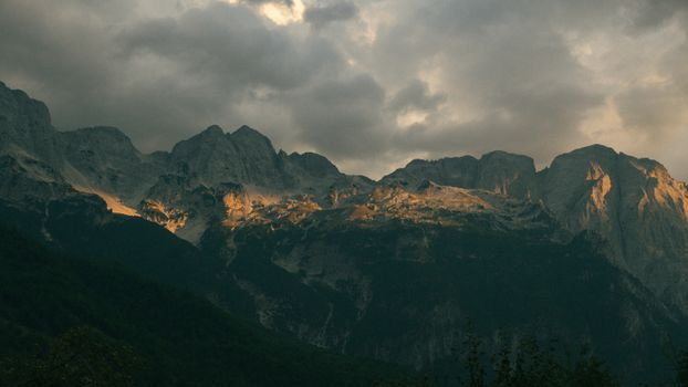 Breathtaking view of the Albanian Alps in Valbonë at sunset, capturing serene mountain beauty.