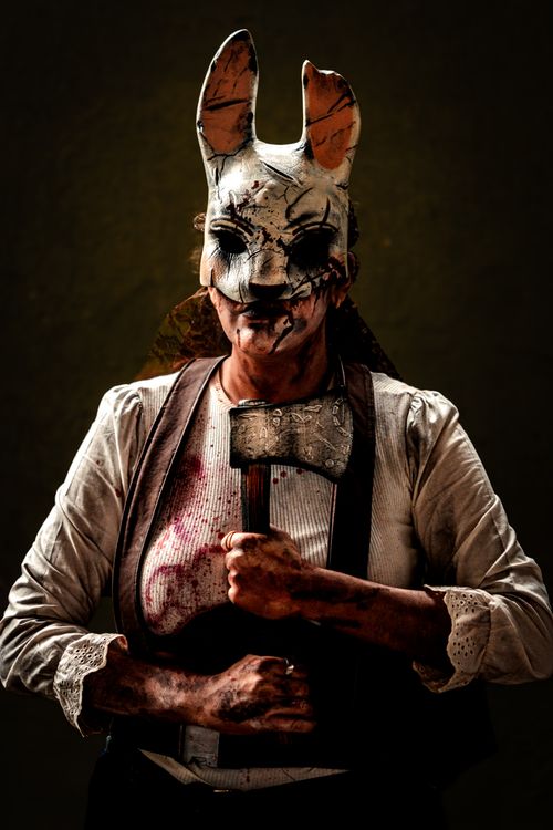 Free Spooky figure in a rabbit mask and bloody costume, holding an axe. Stock Photo