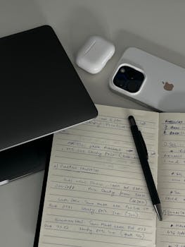 A modern workspace featuring a notebook, smartphone, and tech gadgets, ideal for productivity.