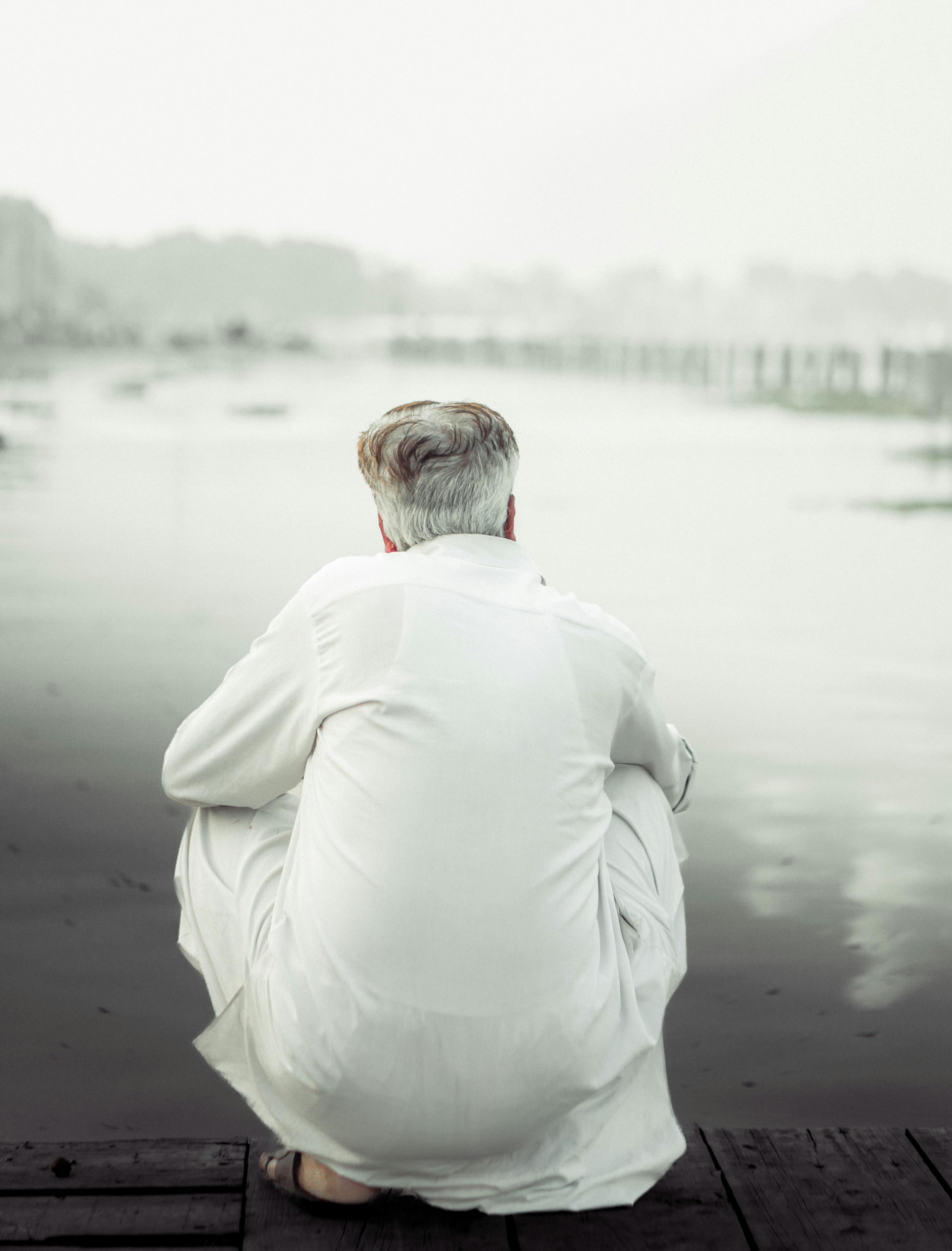 contemplative senior by serene waterside