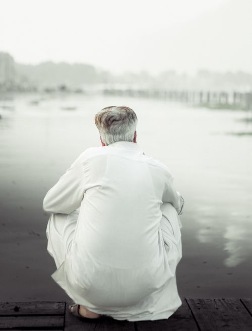 Free Elderly man gazing at serene waterside, evoking contemplation and calmness. Stock Photo