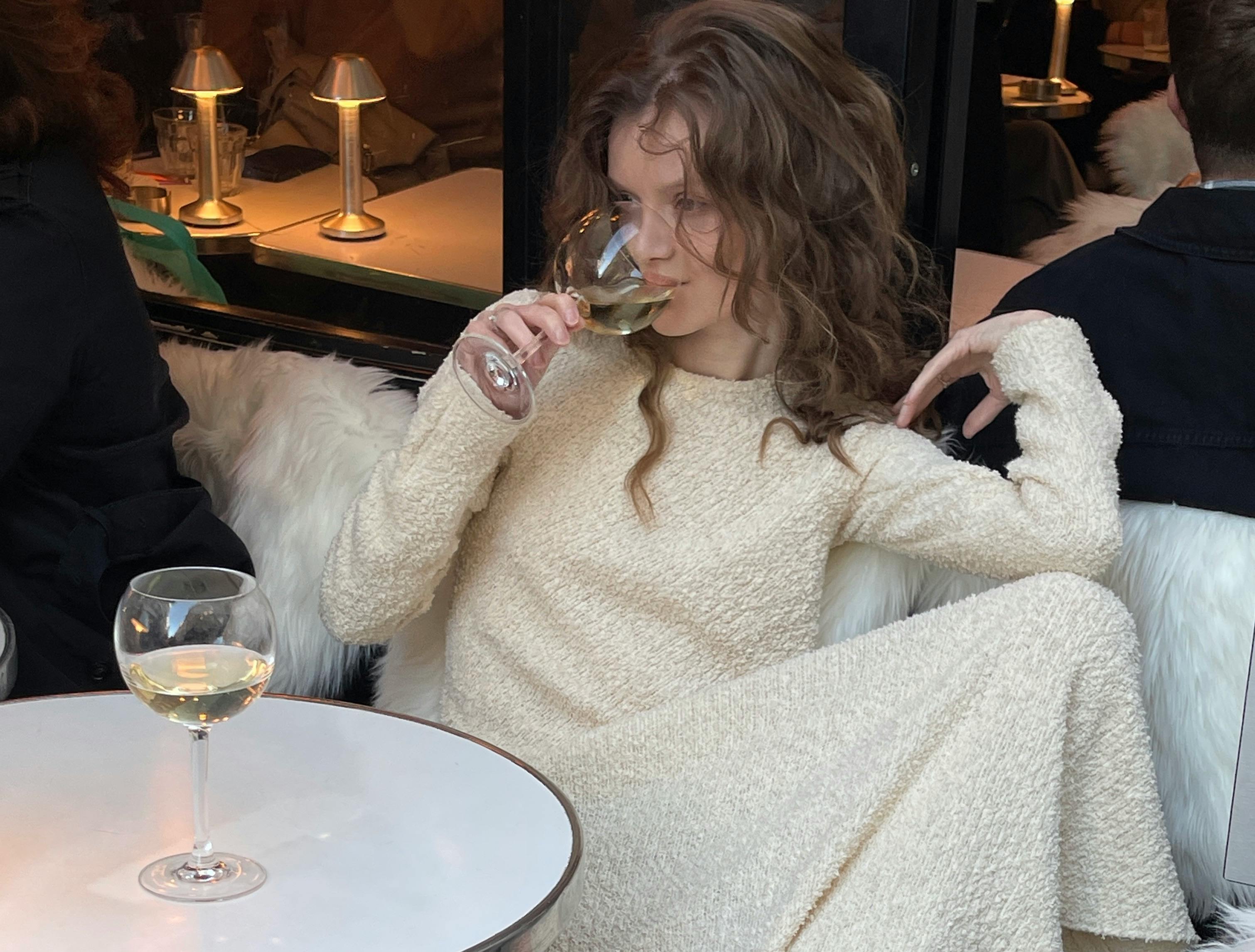 relaxed woman enjoying wine at cozy cafe