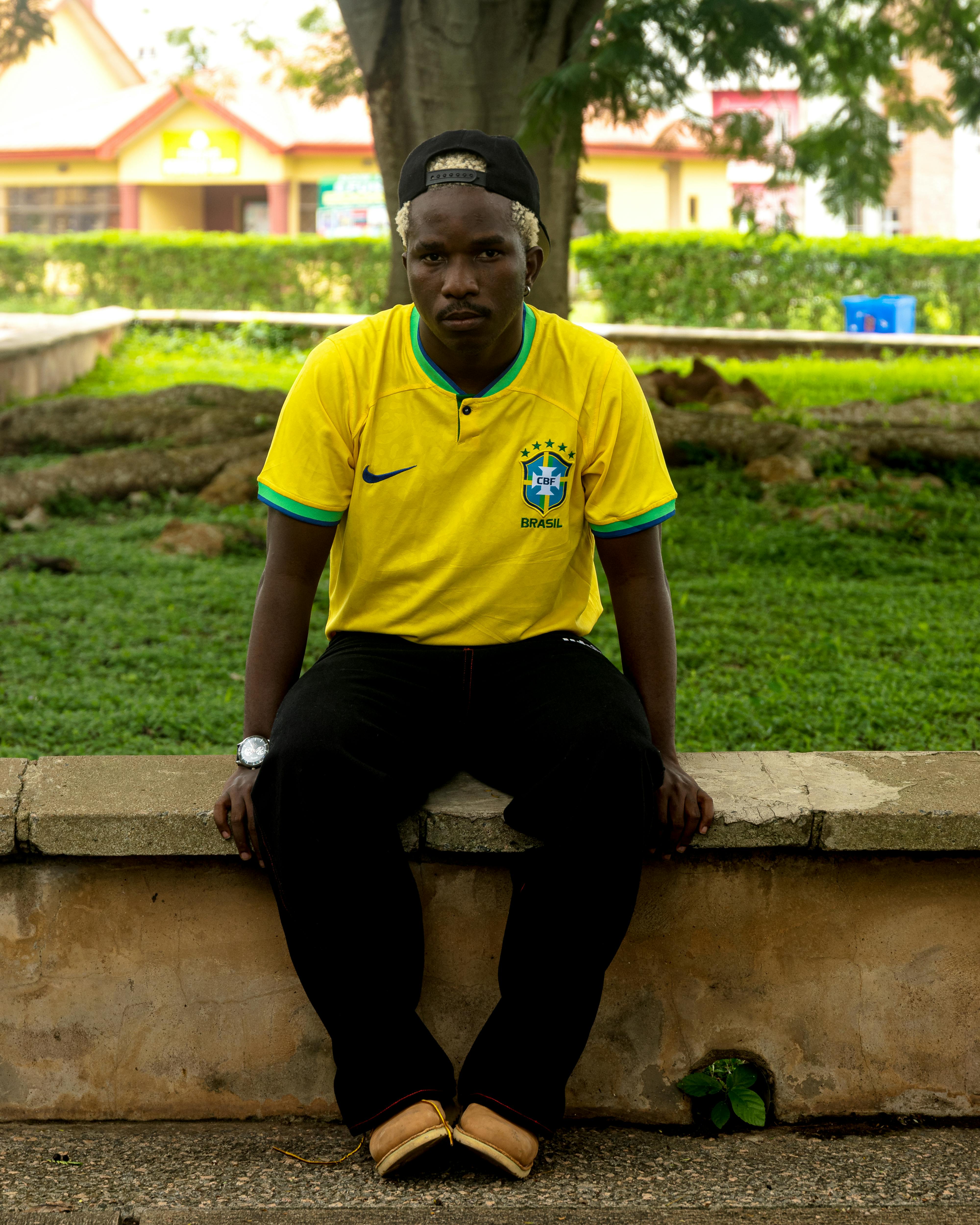 young man in yellow jersey sitting outdoors