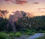 在山地景观中，松树和日落时的河流构成了一幅美丽的画面