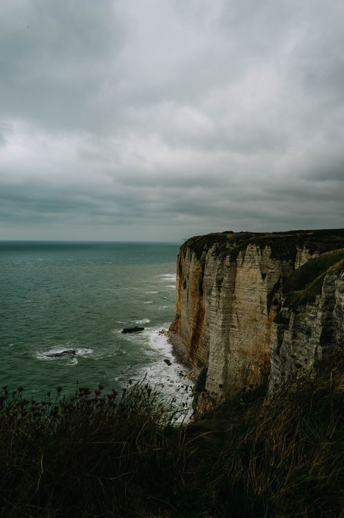 Free Majestic coastal cliffs with stormy skies and rough sea in a moody landscape. Stock Photo