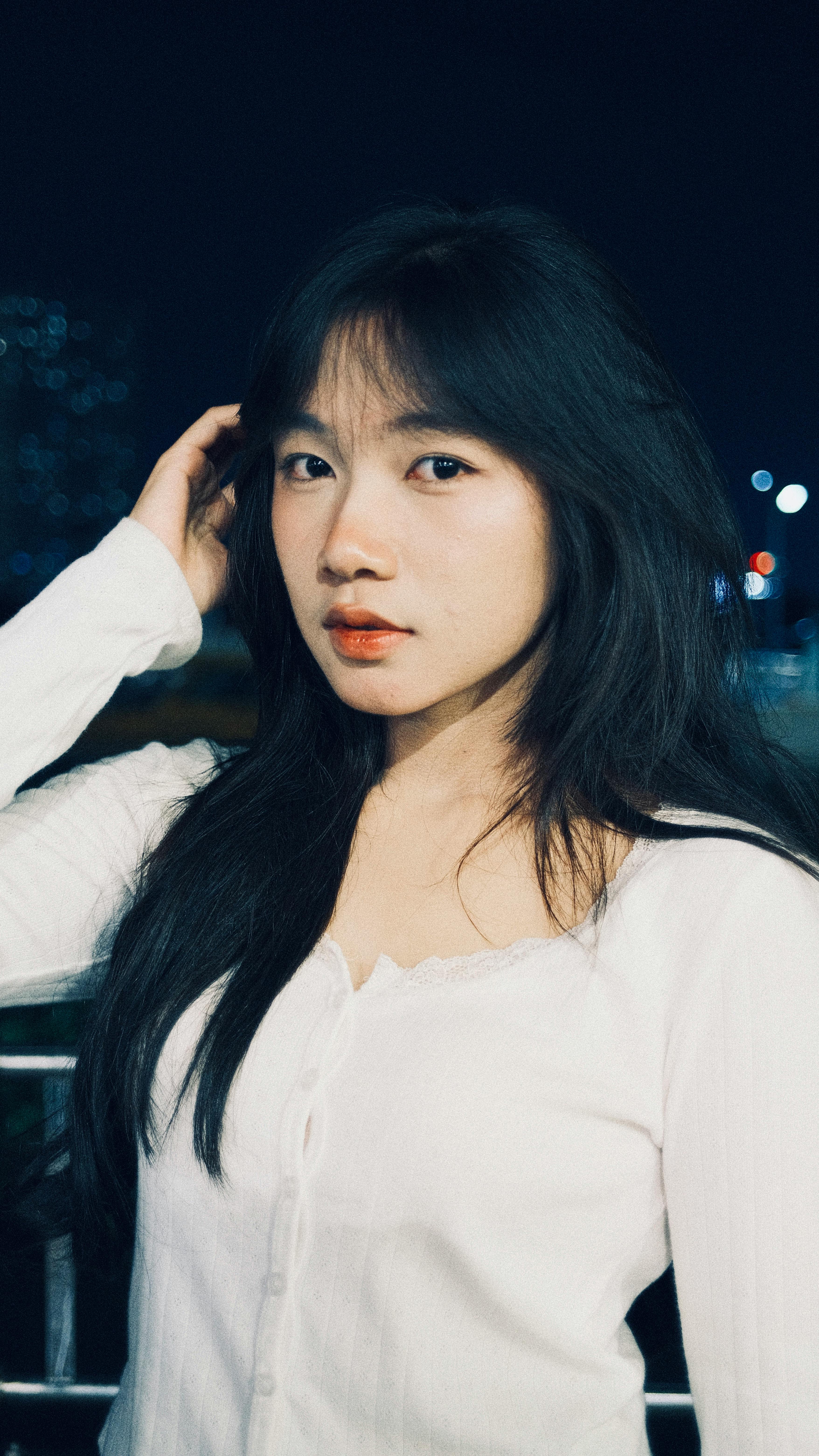 Elegant portrait of woman with long hair against night lights.