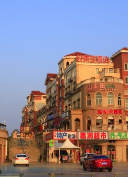 Sunny urban scene showcasing colorful multistory buildings with Chinese signage.